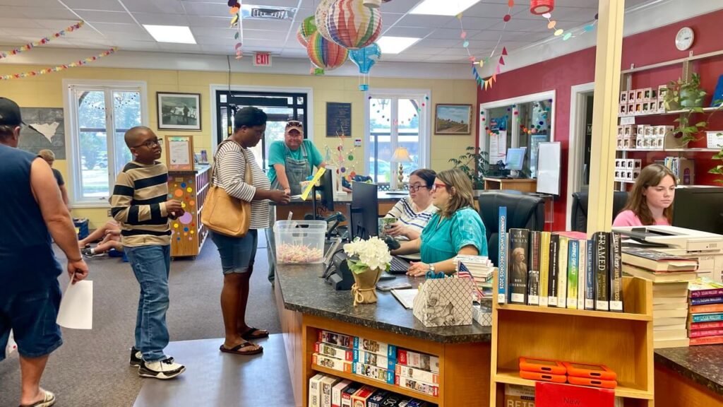 Several library users stand in line to check out books at the Rogersville Public Library