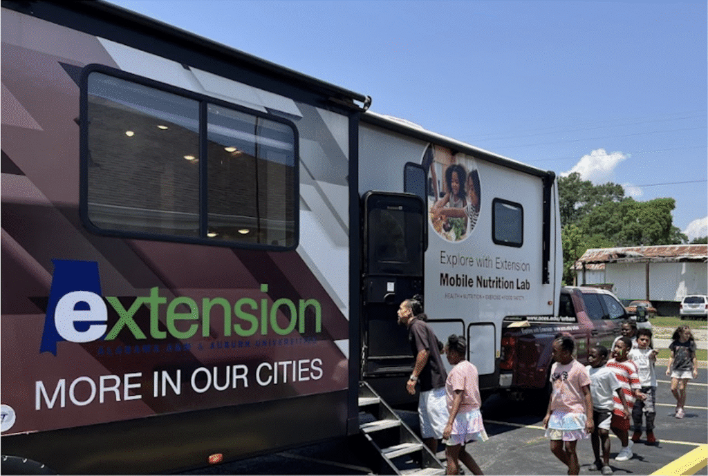 Elementary-aged children in line to participate in the activites inside the Alabama Cooperative Extension System & Alabama A&M's educational RV at the Town Creek Public Library